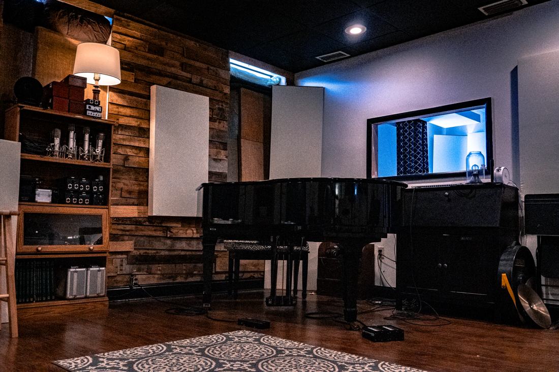 Live tracking room with grand piano and control-room window